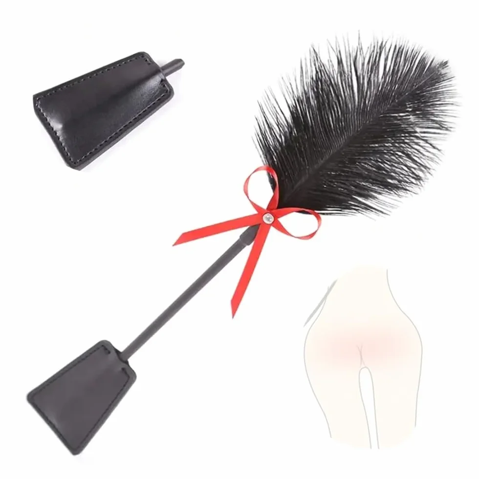 Paddling in pelle nera con piume per punizioni di gioco