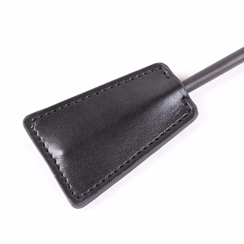 Paddling in pelle nera con piume per punizioni di gioco